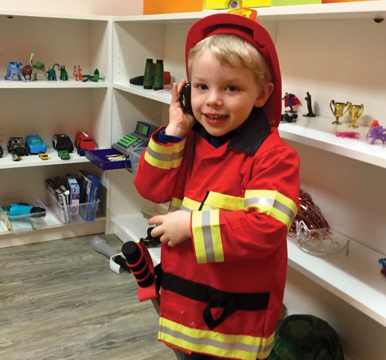 Child playing pretend in firefighter costume