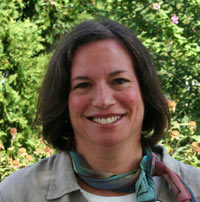 A photograph of Dr. Kathi Borden, a headshot. She wears a colorful silk scarf knotted at her neck and has brown hair.