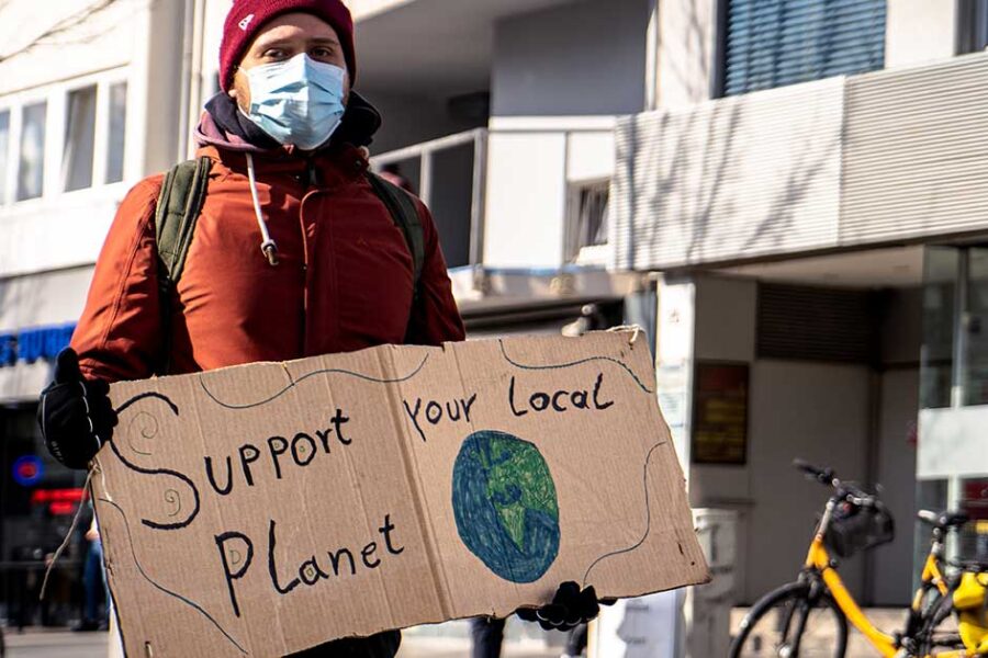 Activists holding sign reading "Support your Local Planet"