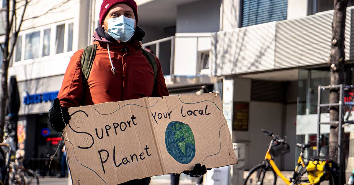 Activists holding sign reading "Support your Local Planet"