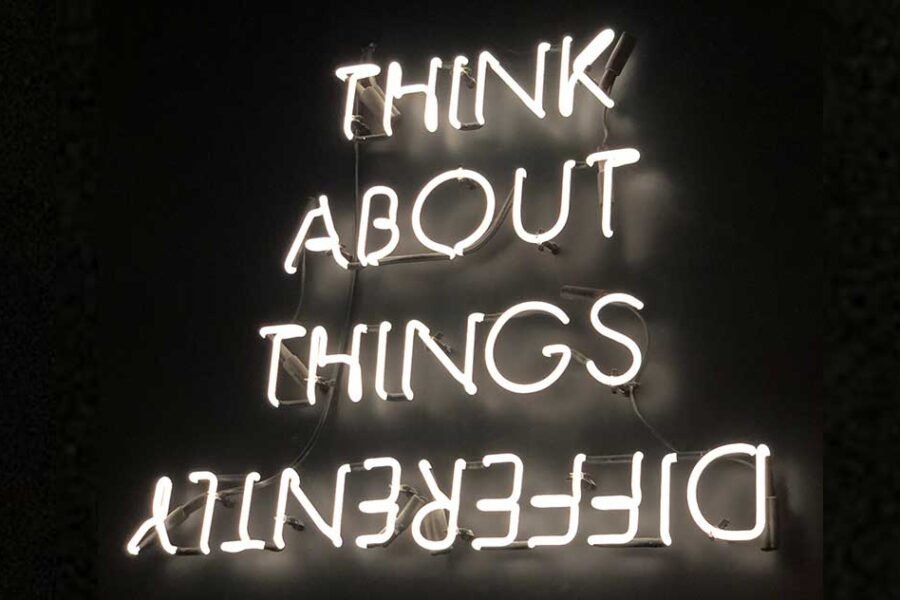 neon light that says "Think About Things Differently" and differently is upside down.