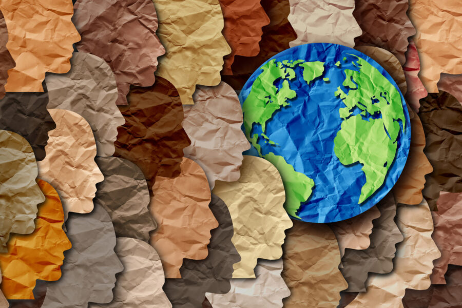 Paper planet earth surrounded by many diverse paper faces