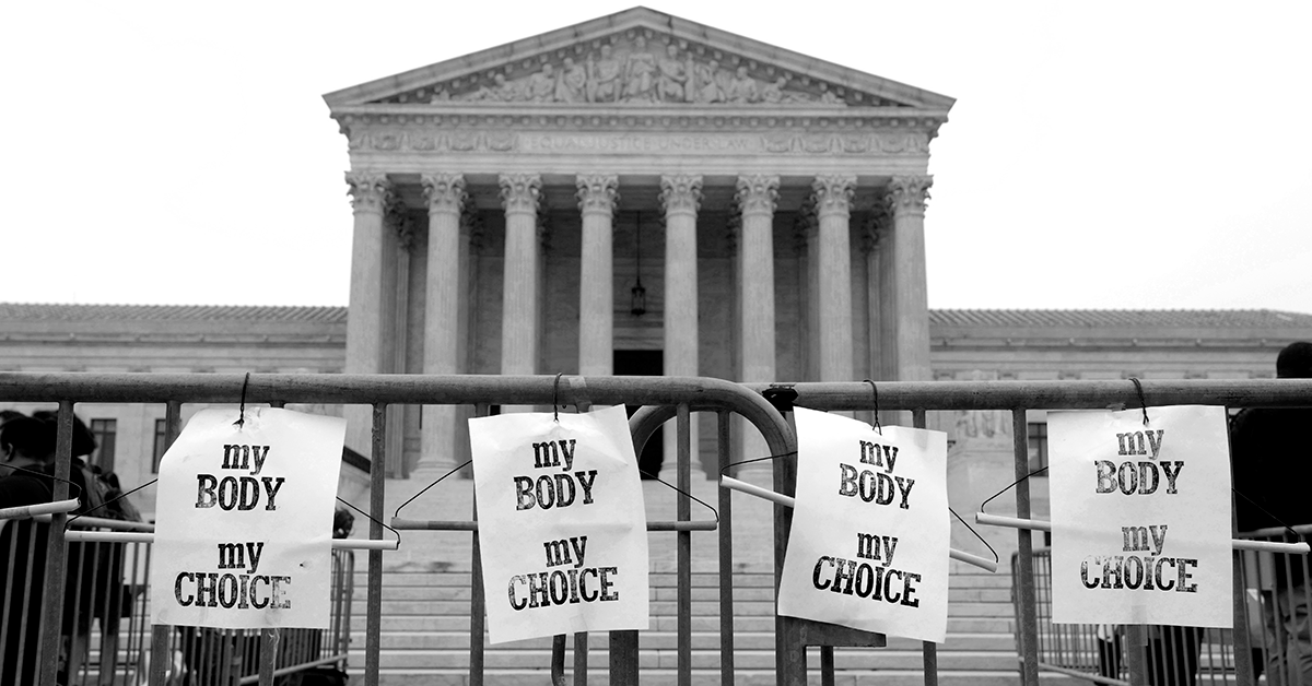 A photo of the Supreme Court of the United States building, behind a fence on which posters reading "My Body My Choice" have been attached.