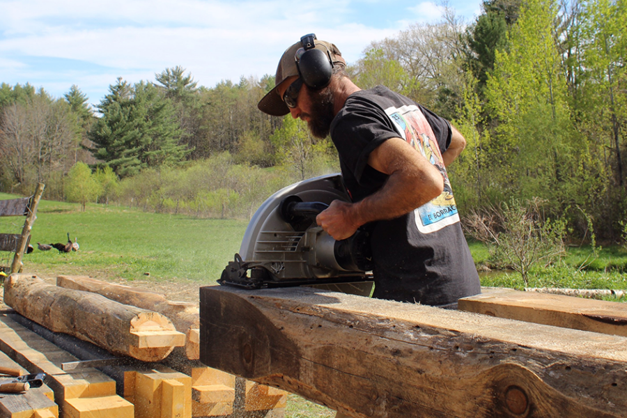 Marty Castriotta sawing large pieces of wood