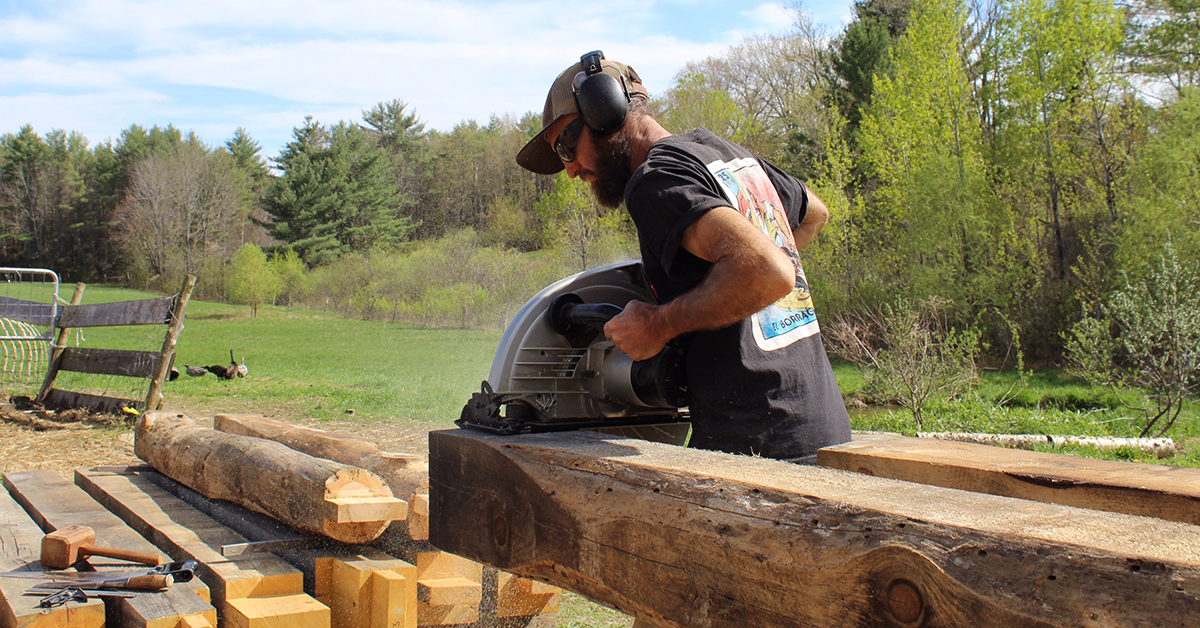 Marty Castriotta sawing large pieces of wood