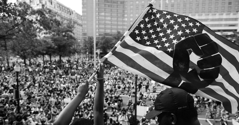 An American flag being held at a rally