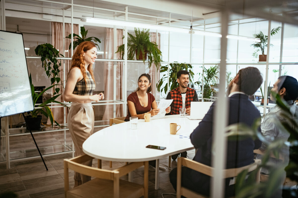 Redhead Latina presenting analysis to colleagues in eco-friendly office