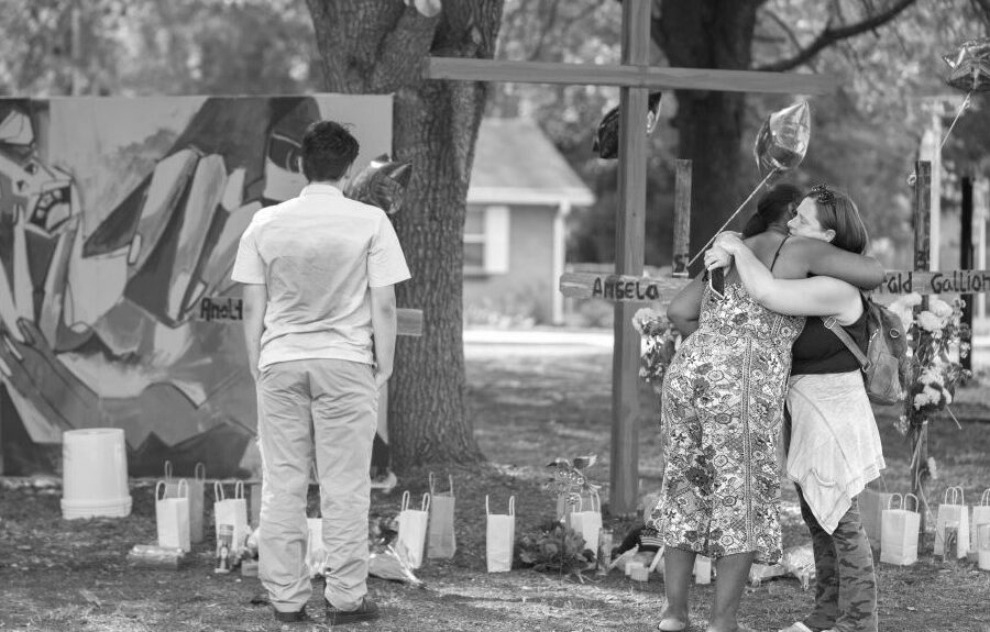 People comfort one another at a memorial for Jerrald Gallion, Angela Carr and Anolt Joseph Laguerre Jr. near a Dollar General store where the three were shot and killed