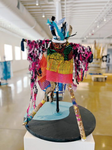 A vibrant fabric sculpture displayed on a pedestal.
