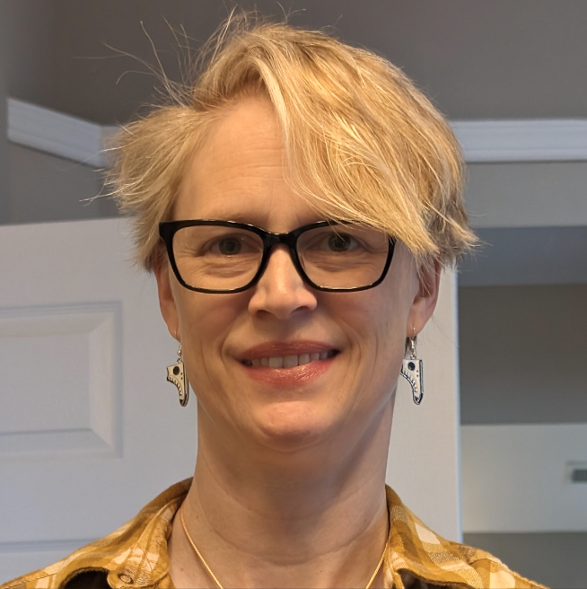 Charlotte Dugan smiling and wearing glasses.
