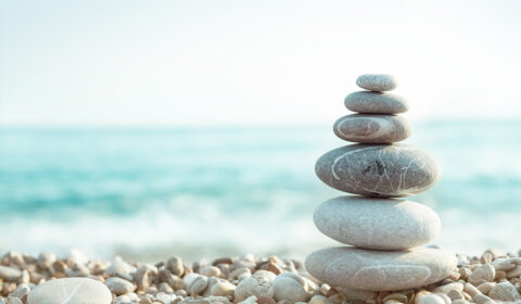 Stacked rocks on the shore in front of the ocean.