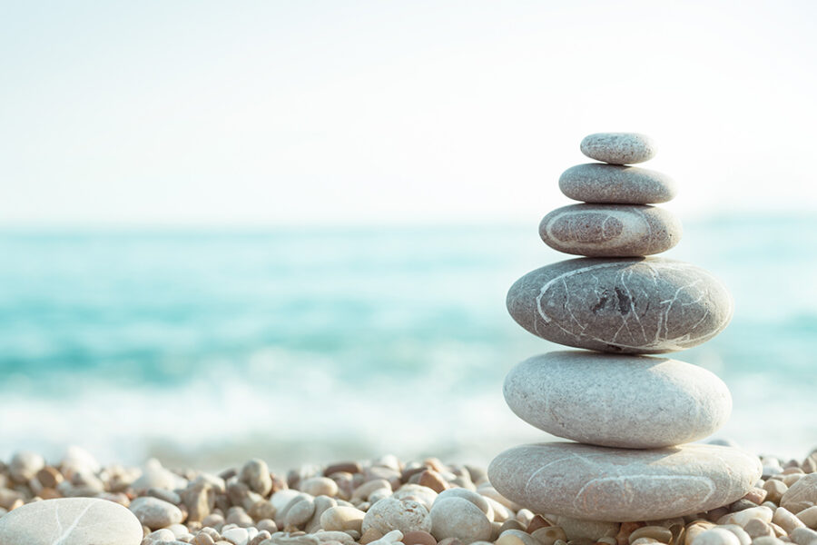 Stacked rocks on the shore in front of the ocean.