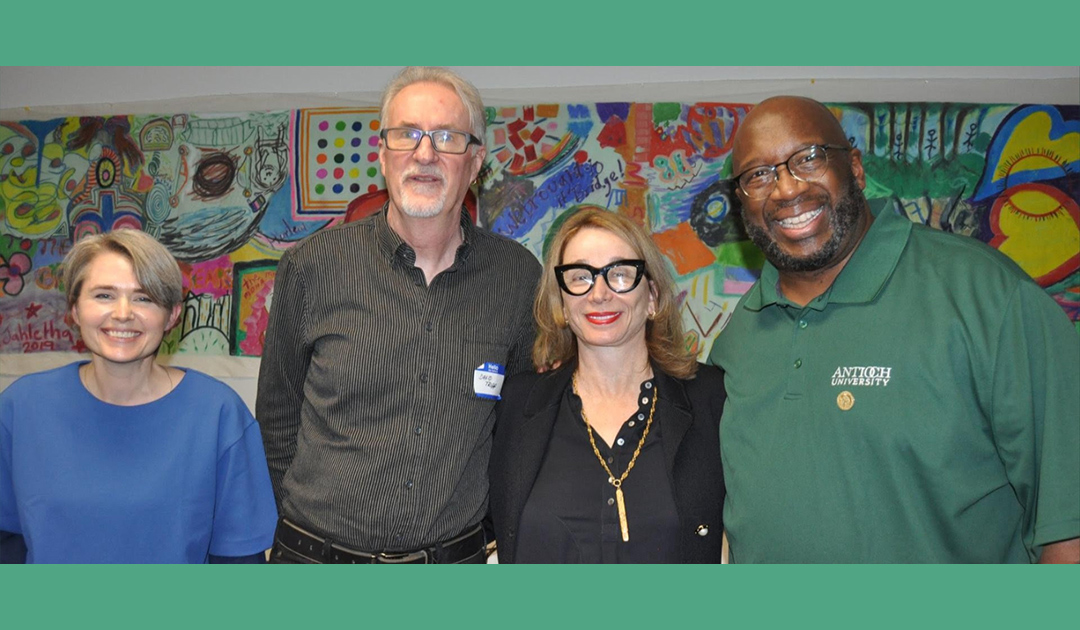 Founders and Directors of Bridge Program (co-founders Shari Foos and David Tripp, co-directors Russell Thornhill and Kathryn Pope)standing in front of a colorful mural.