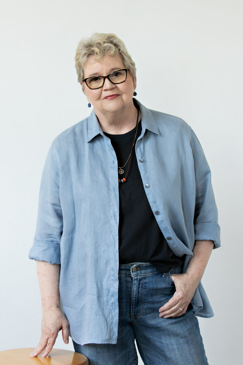 Ronda Jo Downs wearing glasses and a blue demin shirt with a black shirt underneath.