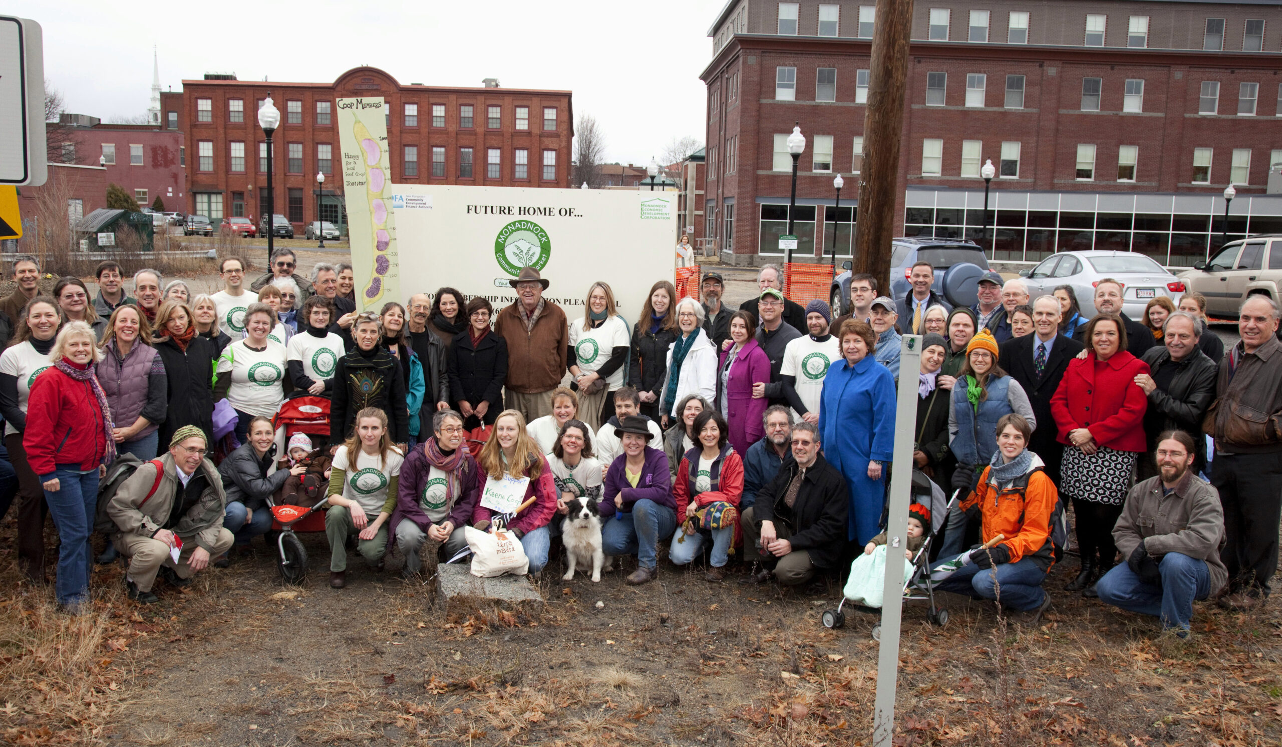 A diverse group of individuals gathered in front of the building site where the future Monadnock Co-op structure will be built.