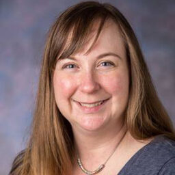 A headshot of Regina Prusinski, who is smiling and looking at the camera.