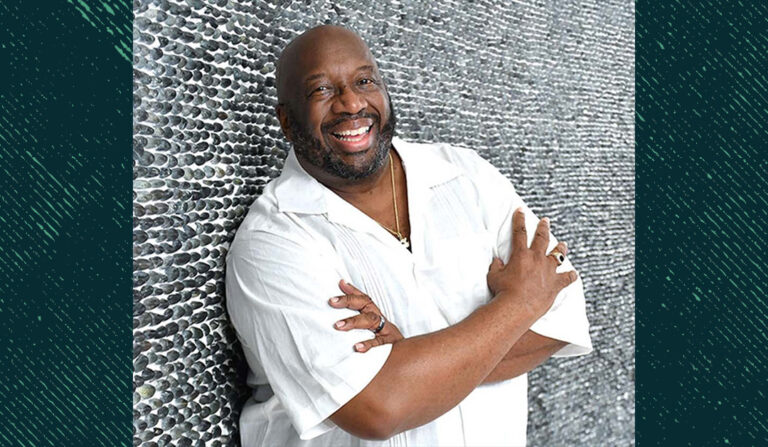 Russell-Thornhill, smiling and standing in front of a brick wall