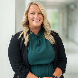 A photo of Ally Smith who is seated and smiling.