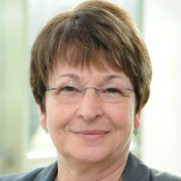 A headshot of Deana Batross who has a short haircut and is wearing glasses