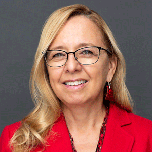 A headshot of Diane Richard-Allerdyce, who is wearing a red jacket and eyeglasses.