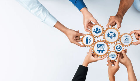 Diverse hands unite to connect gears, symbolizing teamwork and management. This image captures collaboration, strategy, and innovation in a professional setting. Amity