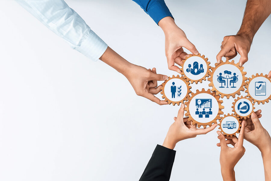 Diverse hands unite to connect gears, symbolizing teamwork and management. This image captures collaboration, strategy, and innovation in a professional setting. Amity