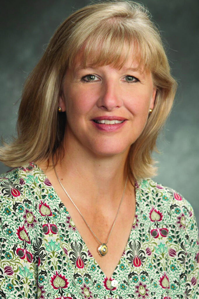 Sandra Madar, leadership at Antioch University, AU, woman, flower top, blonde hair, smile