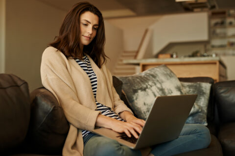 Woman using a laptop on a couch