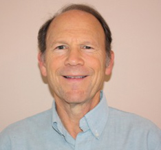 Man smiling at the camera in a light blue shirt