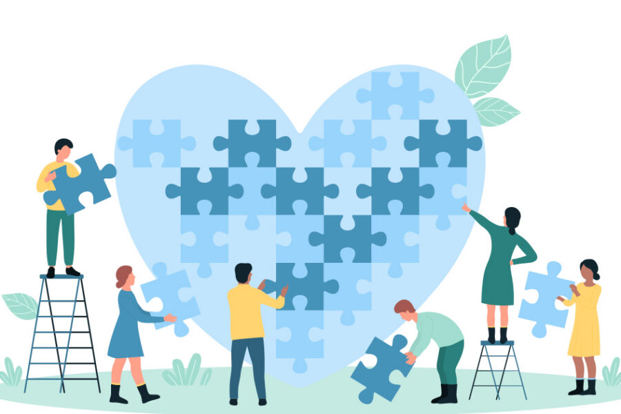 Six people work together to assemble a large heart-shaped puzzle